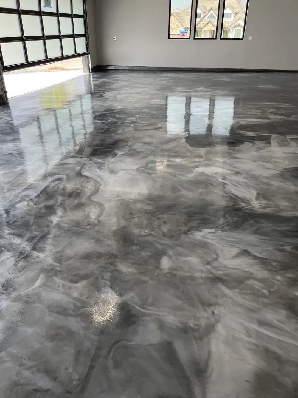 Marbled metallic floor in a garage with window light across it