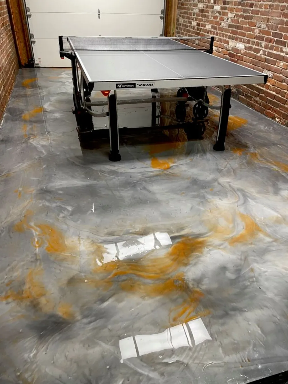 Gray and gold metallic epoxy floor finished with a clear top coat