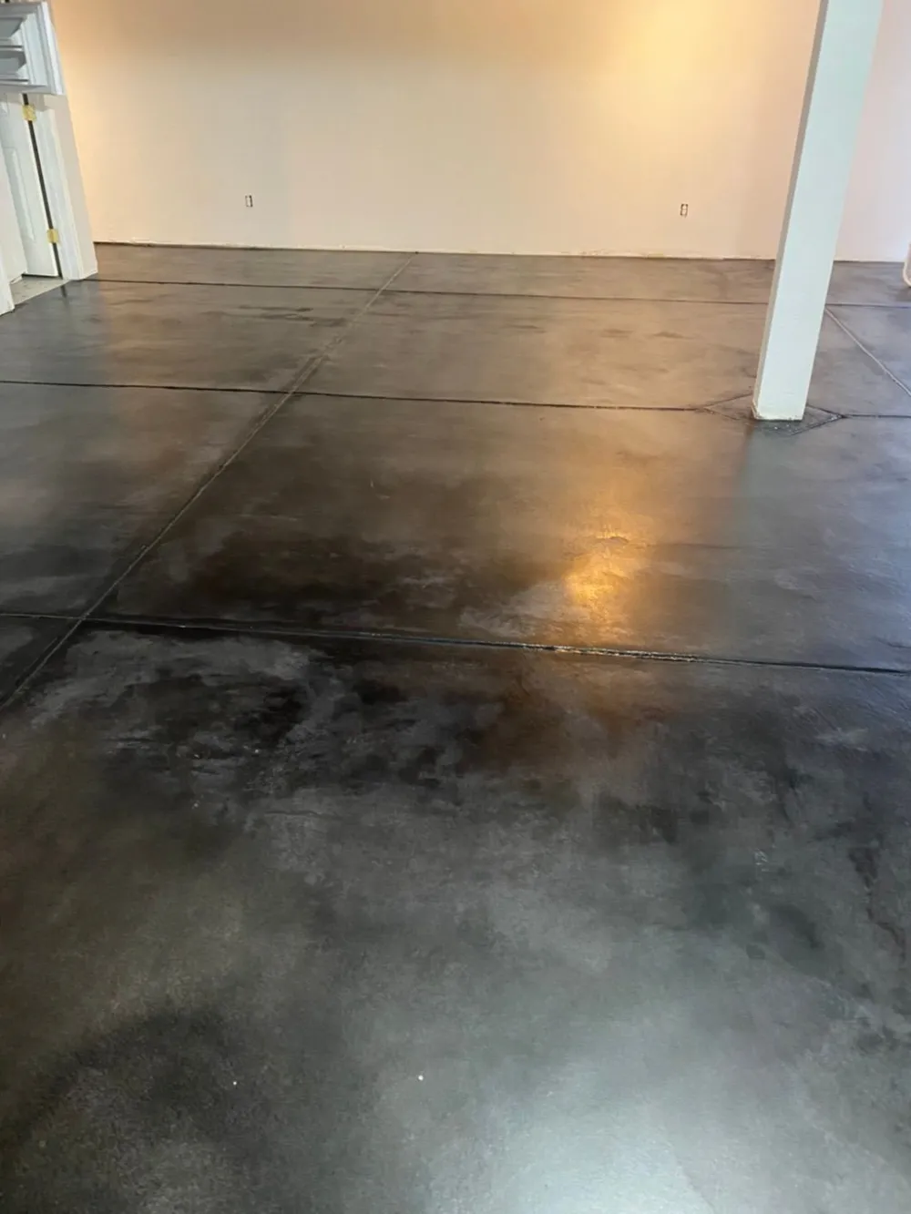Dark stained and polished concrete floor with natural mottled depth and reflection
